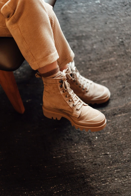 someone is wearing brown shoes and sitting on a chair