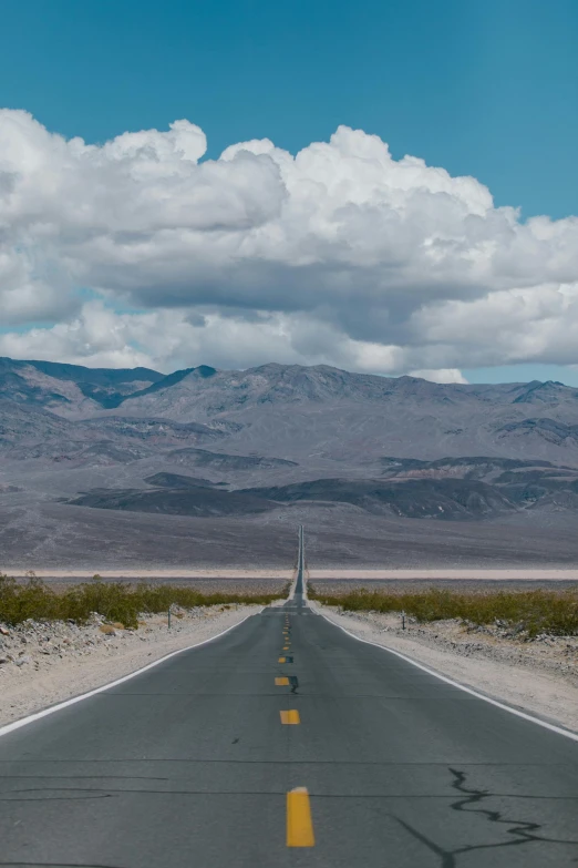 the straight road that is next to a desert