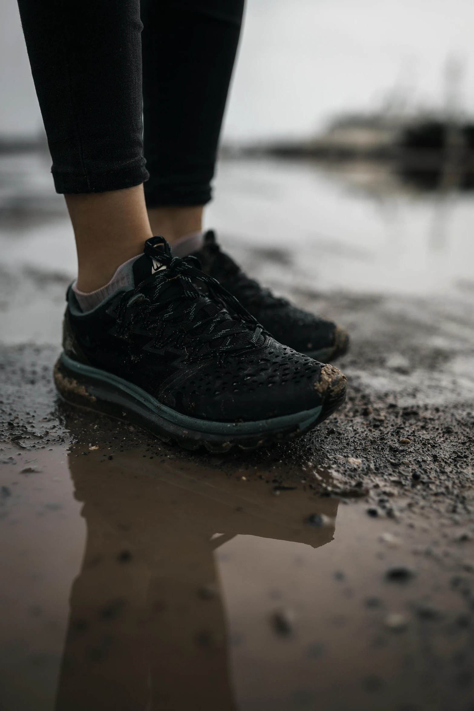 a person walking on the wet ground near water