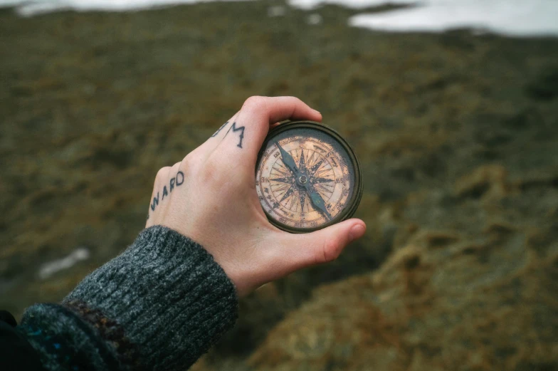 a person is holding a compass in their hand