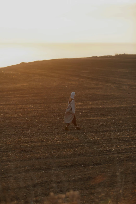 the woman walking through the field is looking at soing