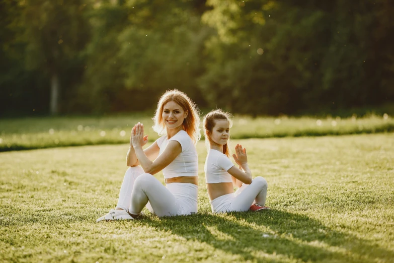 two women are sitting in the grass together