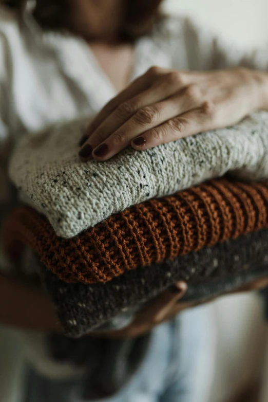 a close - up of a woman holding a pile of blankets