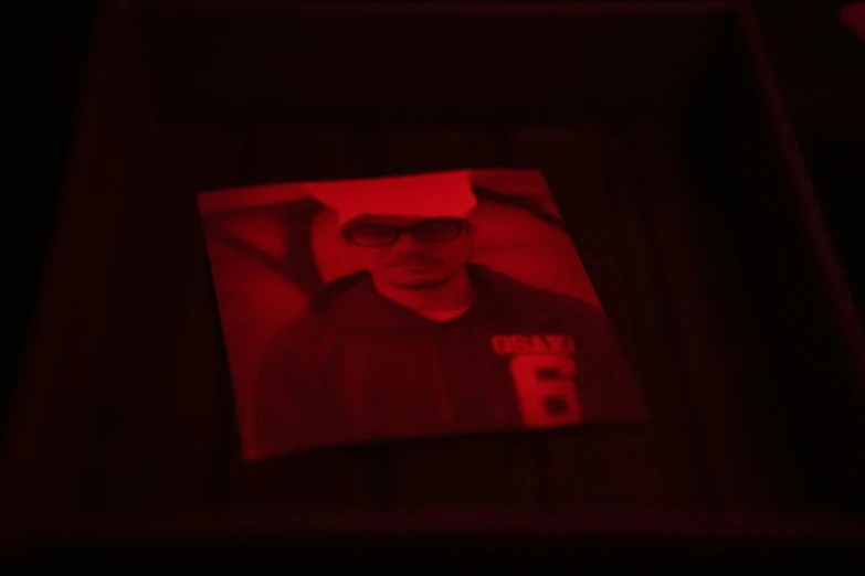 a red picture is being held up to show the face