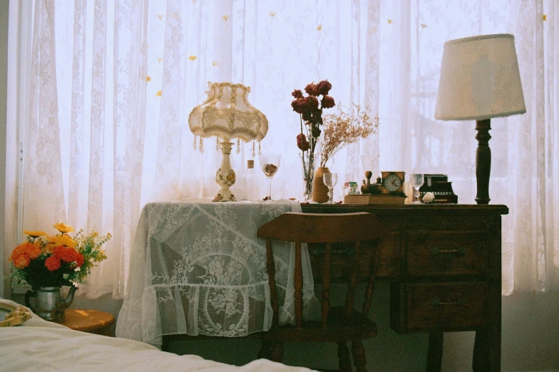 a bedroom with white sheer curtains and a wooden table