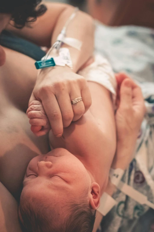 the  of a woman holds the hand of a baby