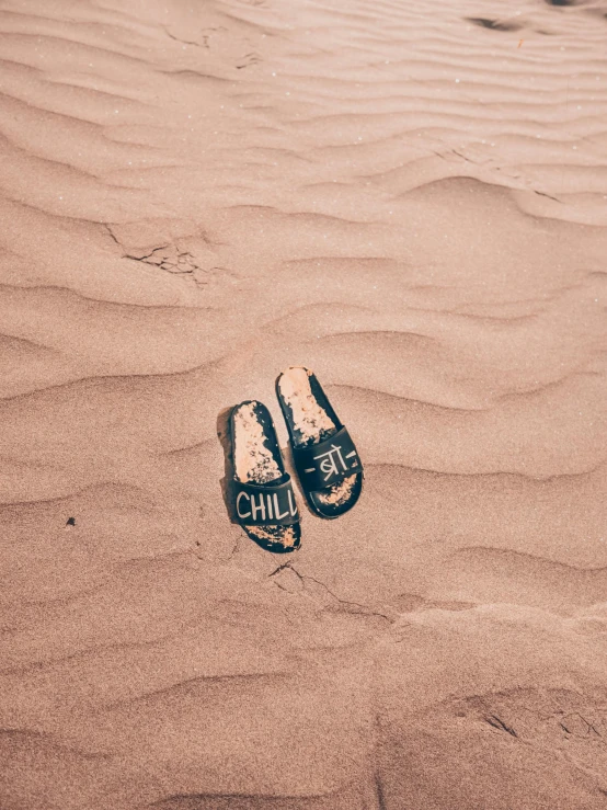 a pair of clogs is left on the sand