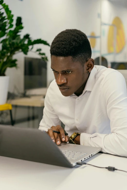 a man sitting at a table in front of a laptop