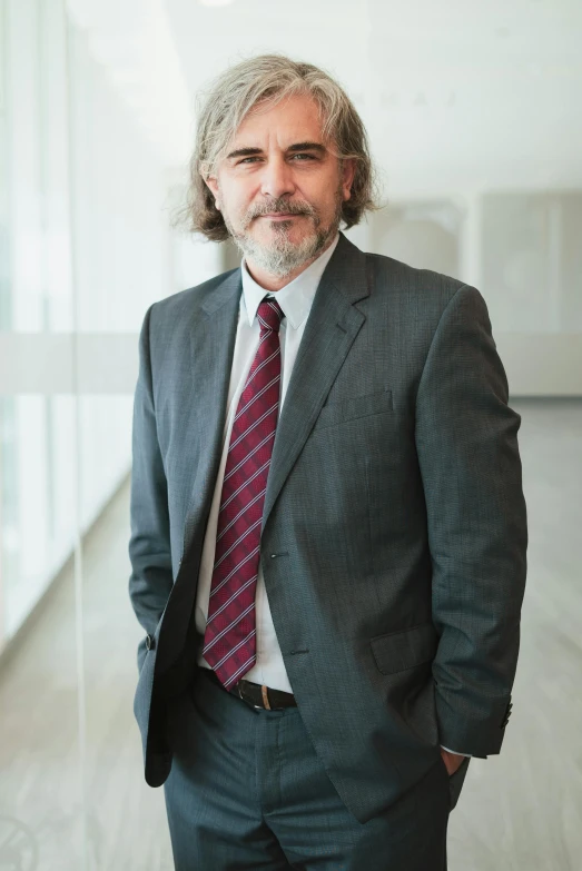 a man with long hair, wearing a suit and tie