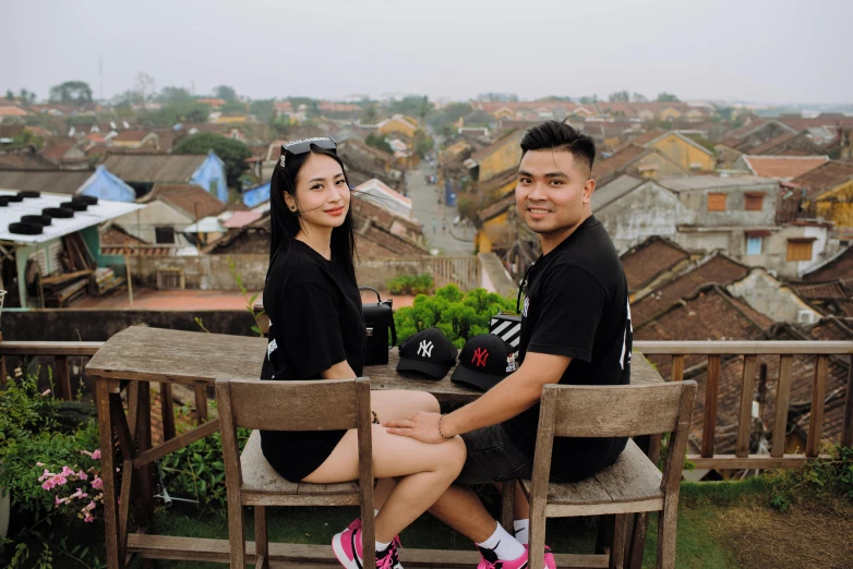 two people sitting next to each other on a wooden bench