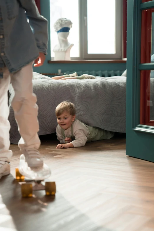 a small child in front of a bed playing on a skateboard