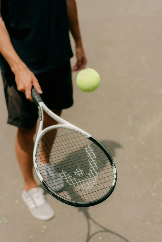 the tennis ball is near a male in black shirt