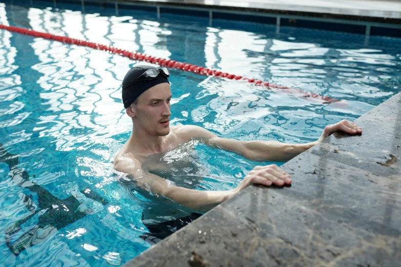 the young man is swimming in the pool