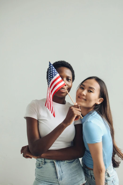 young woman with american flag on a stick with another woman