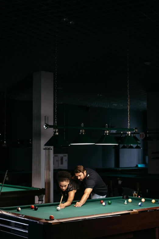 a young man is setting his pool table on the billiard
