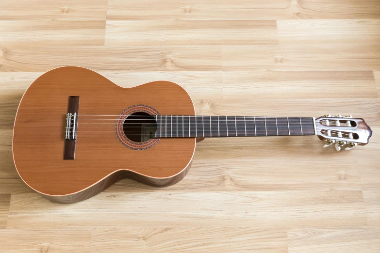 a ukulele is on the floor with an instrument strap