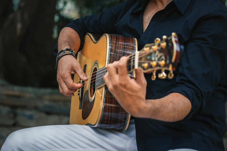 man playing guitar on the beach near the water