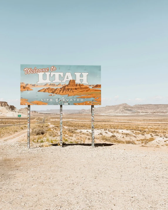 a large blue sign sitting in the middle of a desert