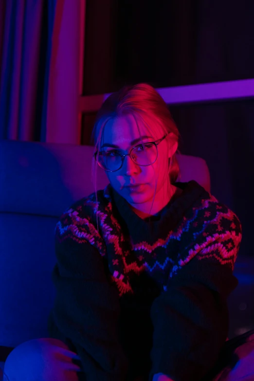a woman sitting on the couch in the dark