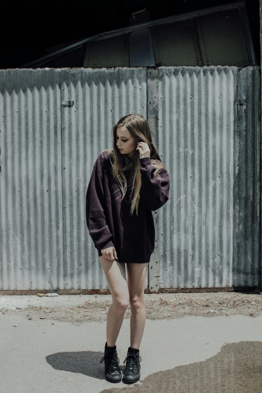 a woman in a black top standing next to a wall