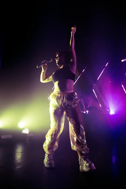 a man is standing on stage with his arms up