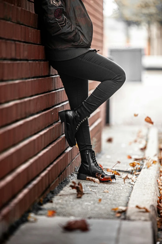 a woman leaning against a wall with her arms up against it