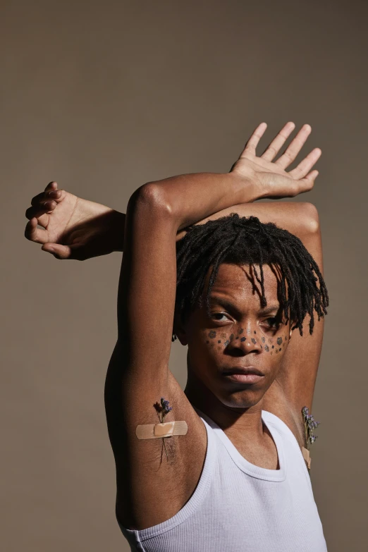 a man with arm tattoos in front of his head