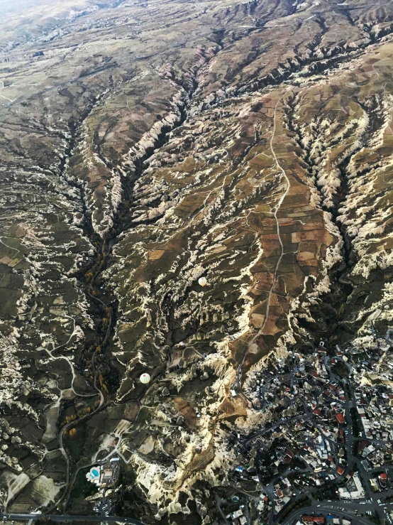 a mountain landscape with trees and buildings with a river in the middle