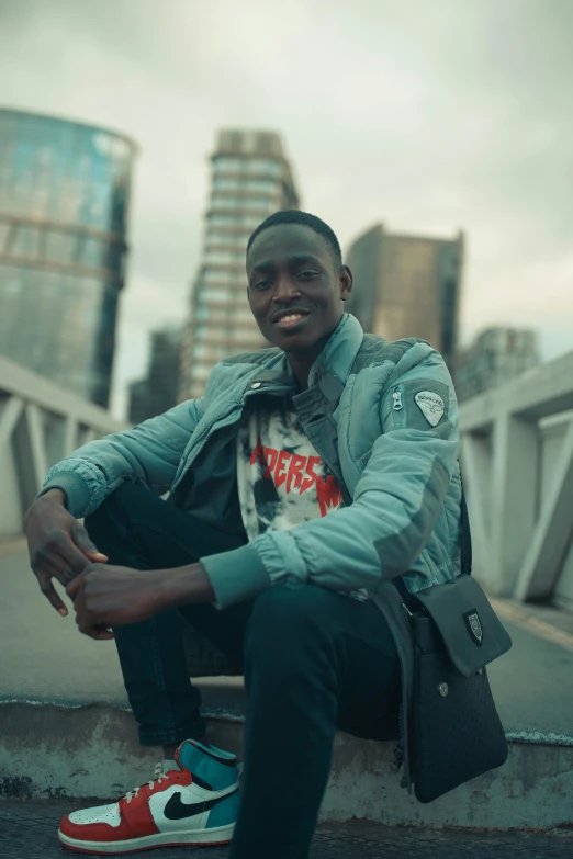 the smiling man is holding a purse sitting on steps