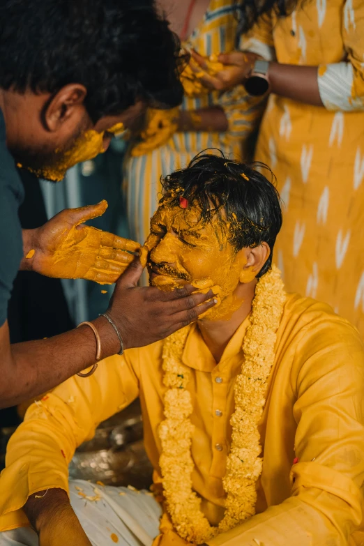a man that is sitting down with a yellow face paint