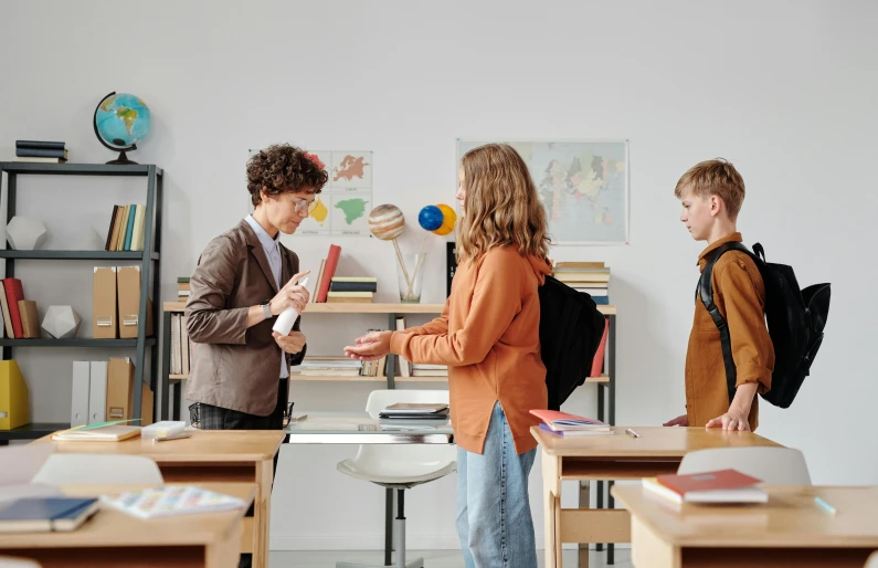 children in an art class with two teachers