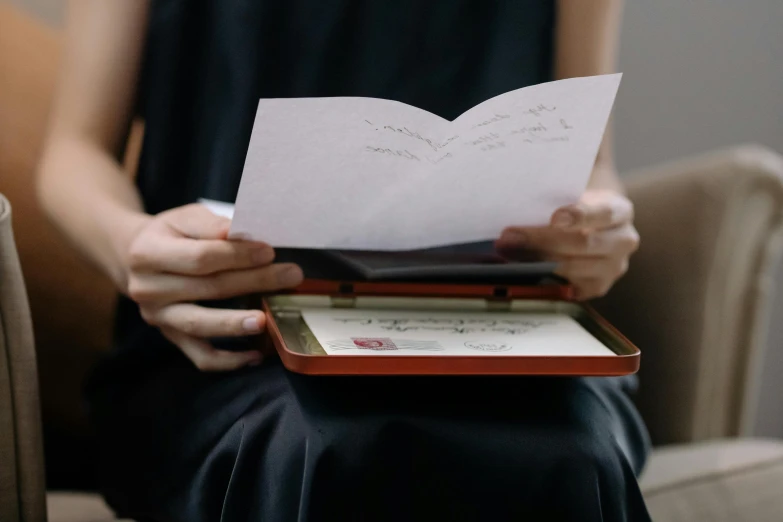 a woman is sitting with a book that reads, love letter