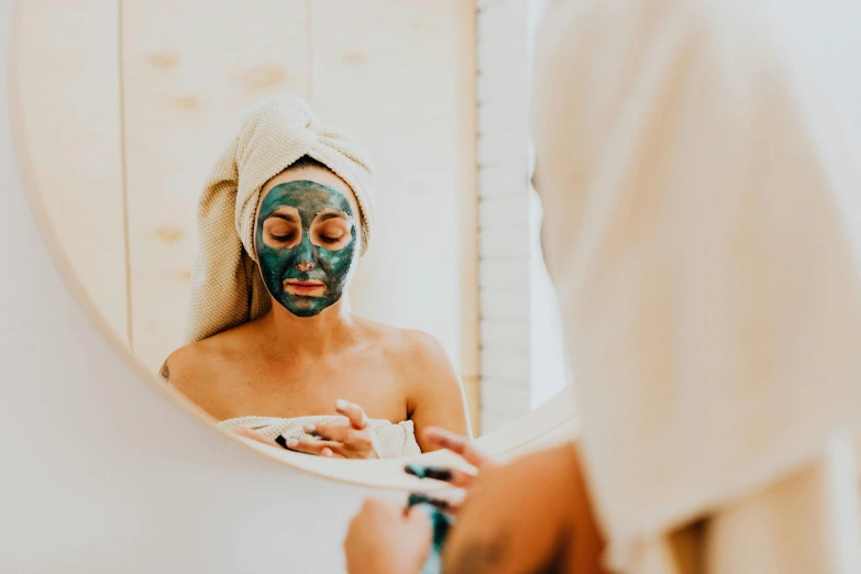 a woman with a black mask washing her face