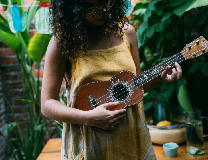 a girl holding onto a ukulele that is upside down