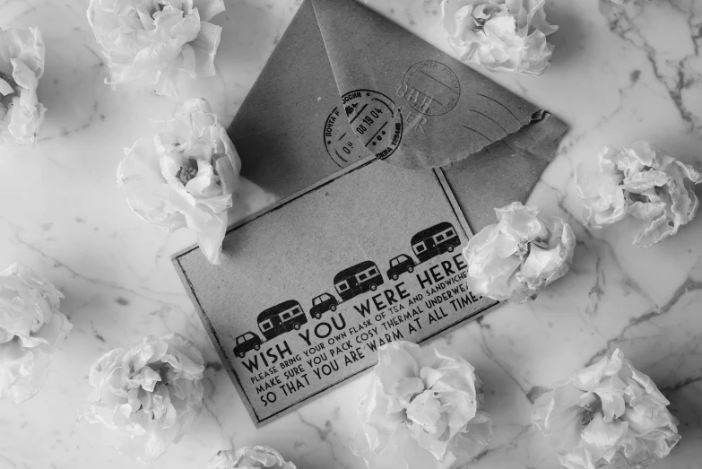 black and white pograph of a mailbox, paper flowers, and stamps