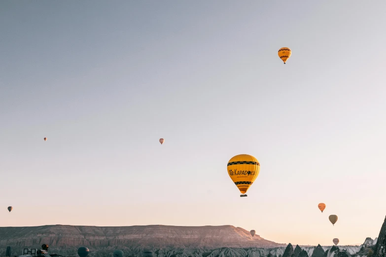 several balloons in the sky near mountains