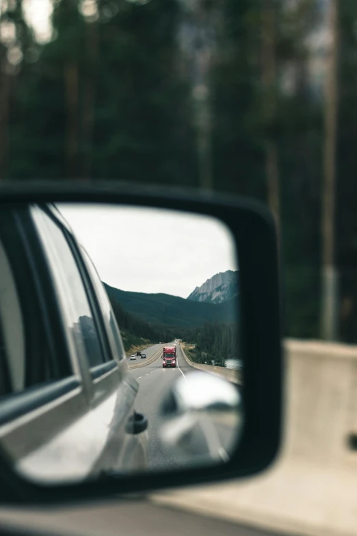 a side mirror of a car on a road