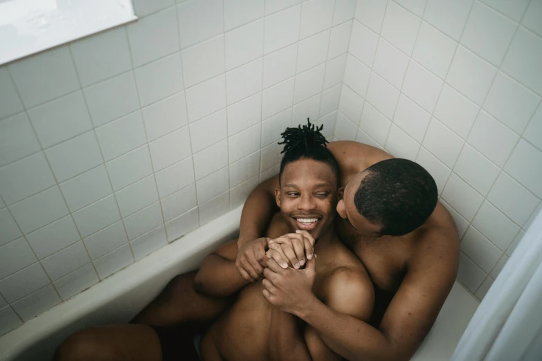 two men are emcing while sitting on the tub