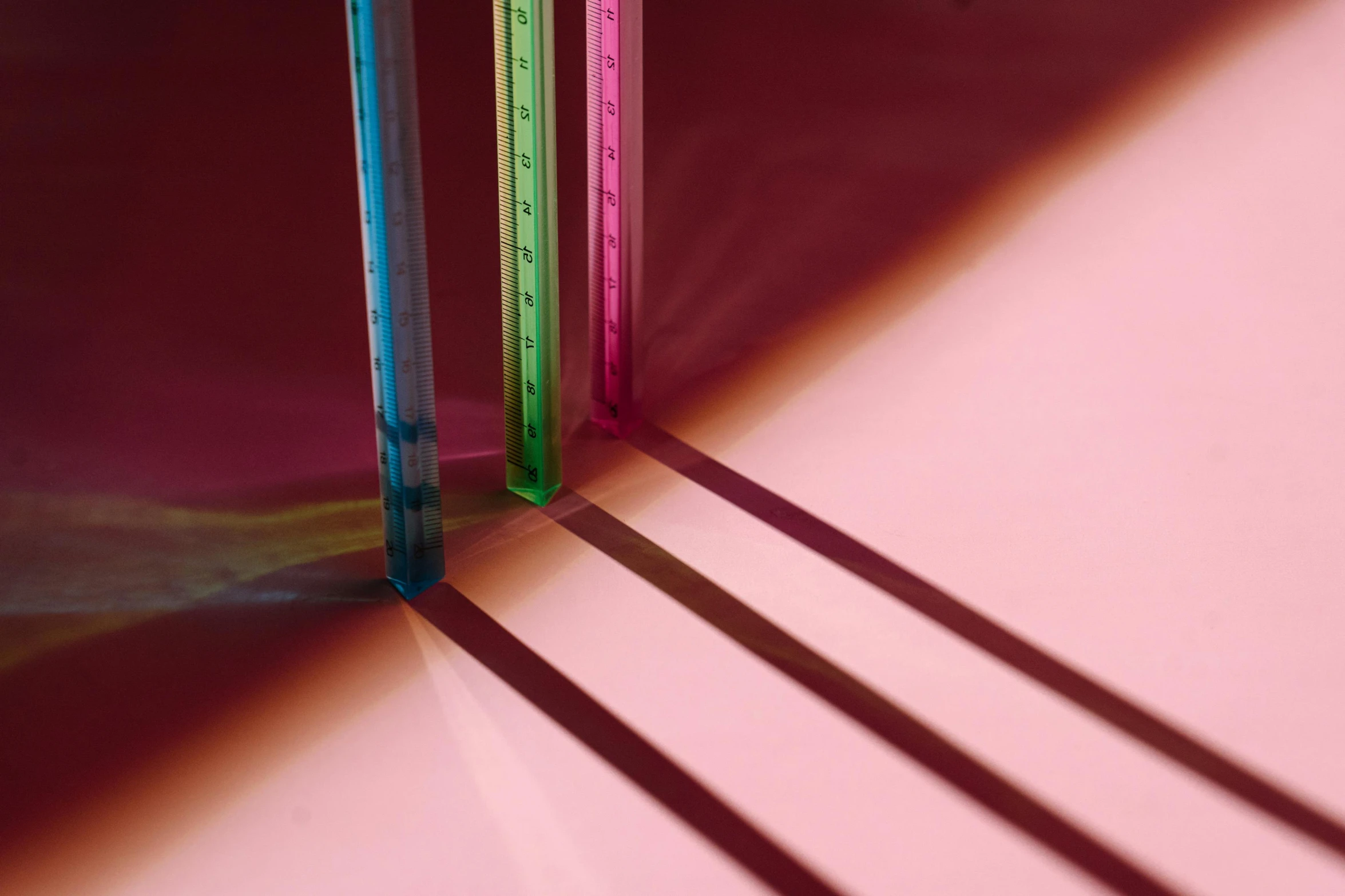 the two rulers are on the table that's pink