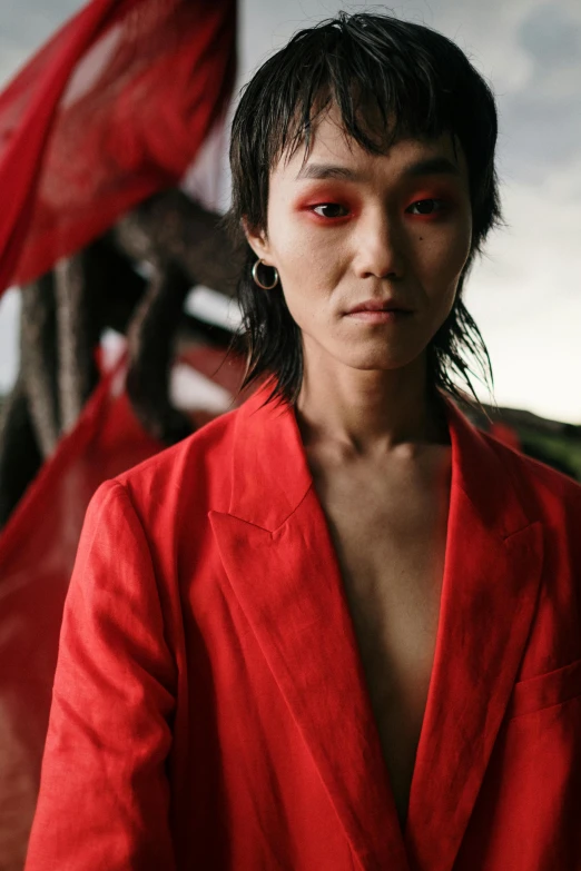 a woman standing by a wall in a red outfit