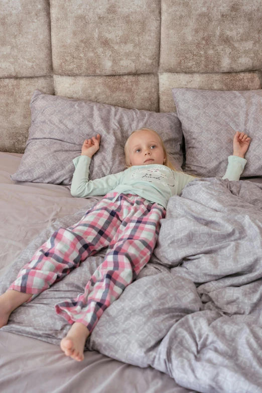 a child lying on a bed with blankets on it