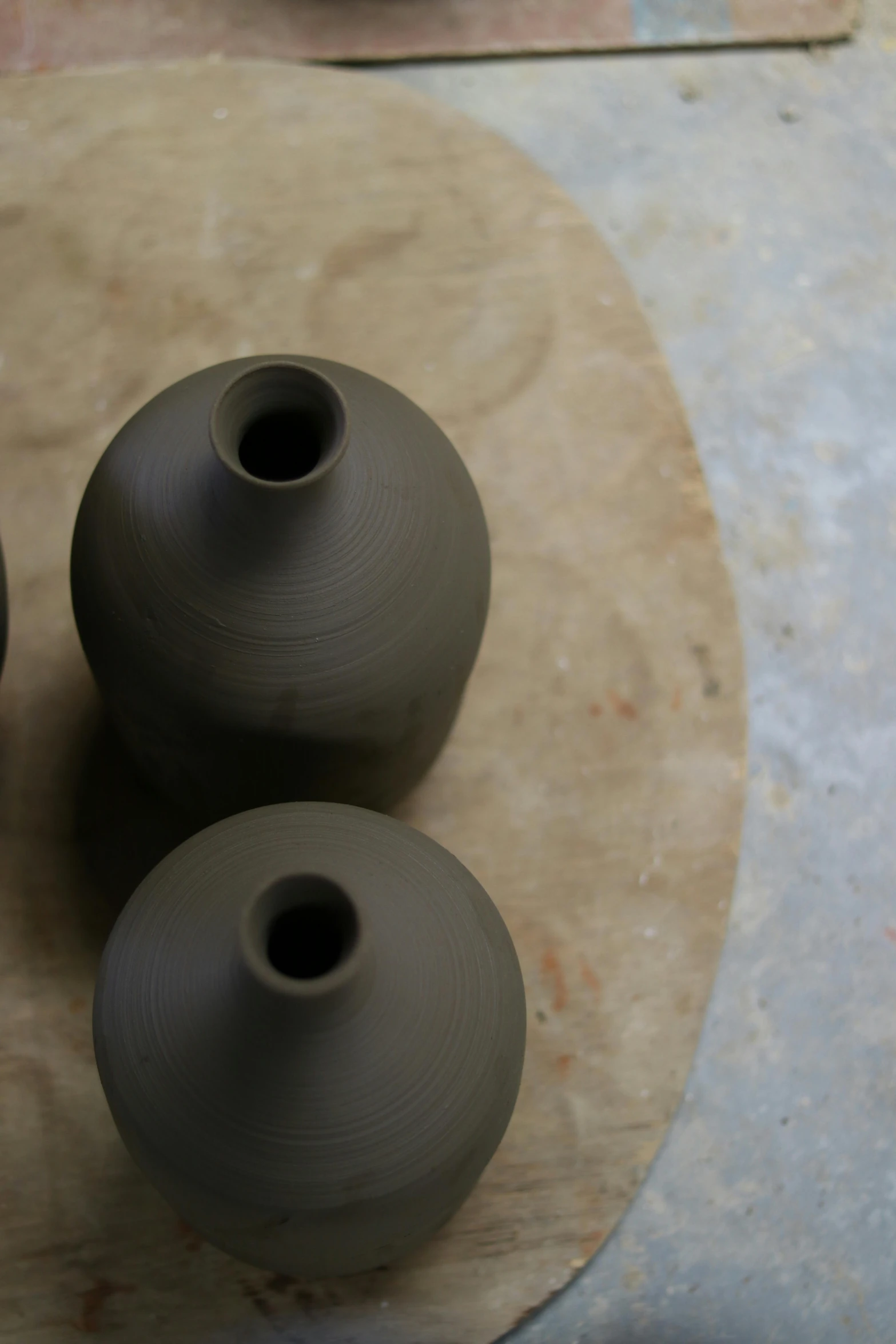 three vases with handles, sitting on a table