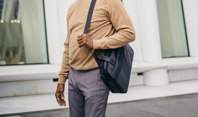 an older man standing outside a store with a bag