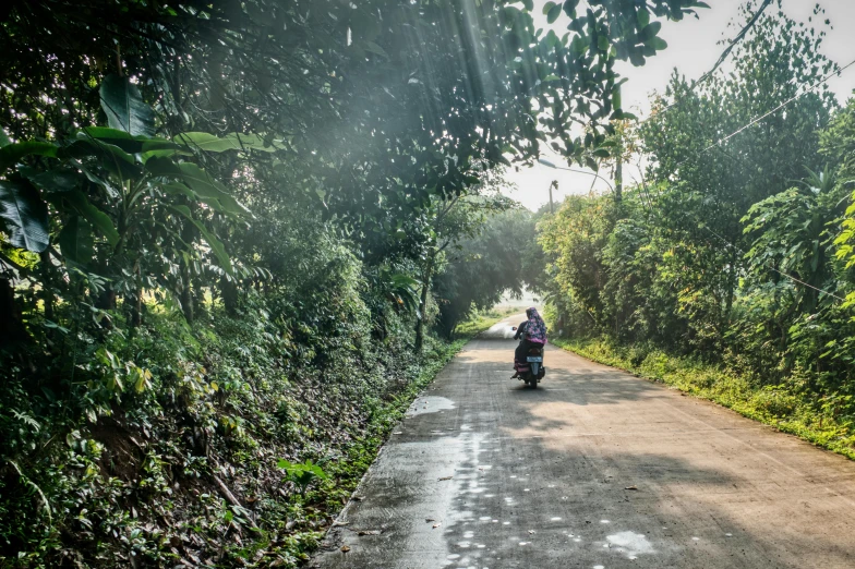 a man riding a motor bike down a country road