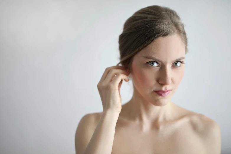 a woman is posing for a po with her hand to her ear