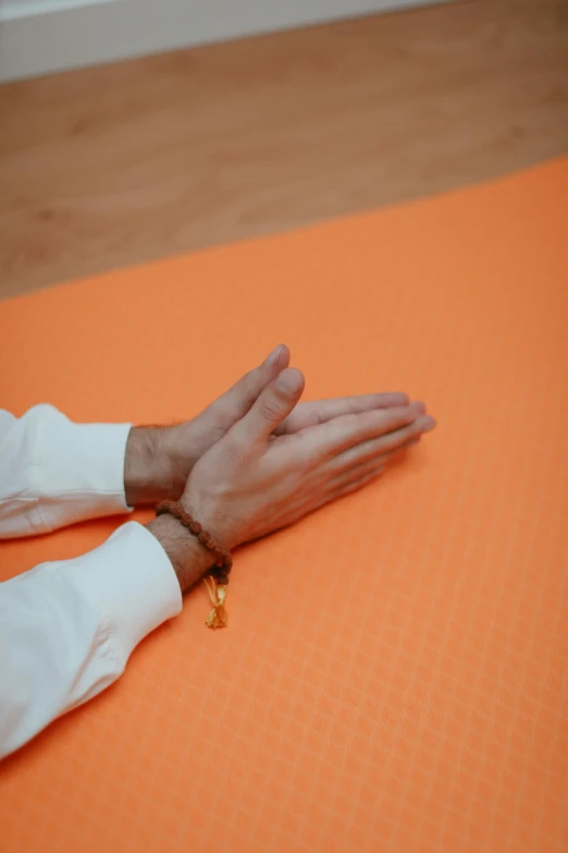 the two hands of a person who are on a mat