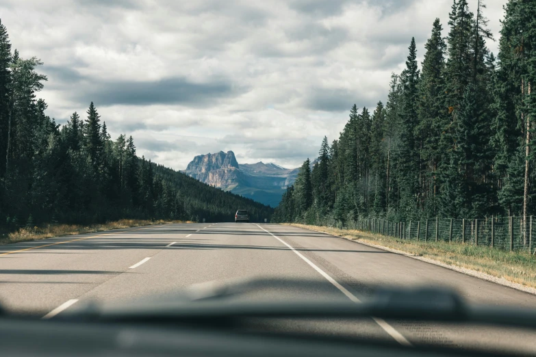 the windshield view of a car on a mountain road