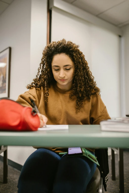 a woman is writing in her notebook at a table