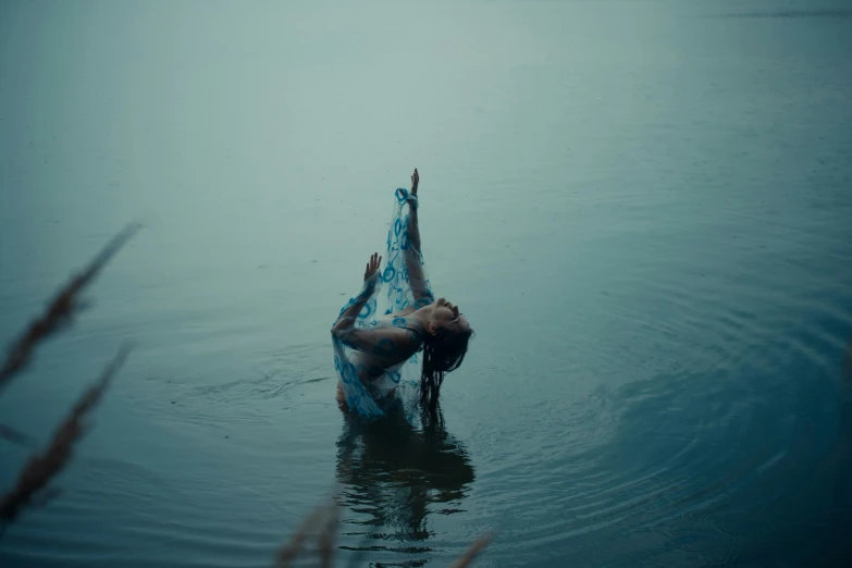 a person in the water touching a pole