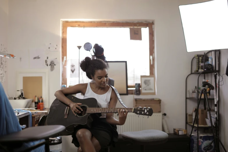 an african american woman playing the guitar